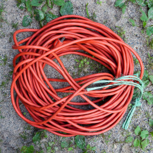Orange Extension cord, in a coil on the ground. Mostly Circular by Roger H. Goun on Flickr, used under a CC-BY 2.0 license.